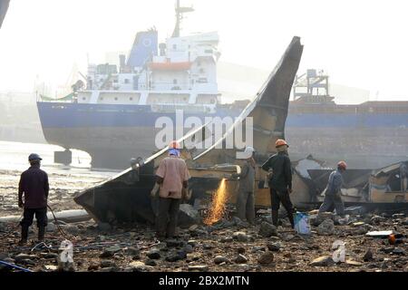 Shipbreaking Yard in Darukhana, Mumbai, Indien – INS Vikrant Abbau mit Schrott & Arbeiter im Hintergrund Stockfoto