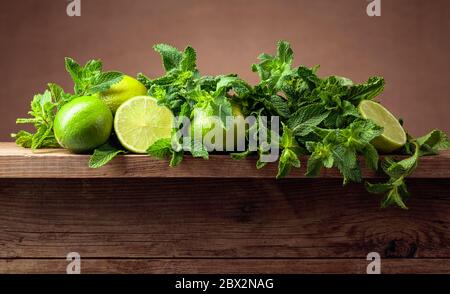 Frische grüne Minze und Limetten auf einem alten Holztisch. Kopierbereich. Stockfoto