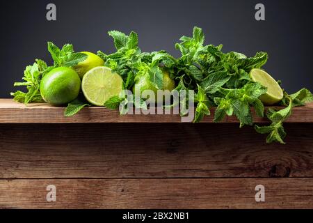 Frische grüne Minze und Limetten auf einem alten Holztisch. Kopierbereich. Stockfoto