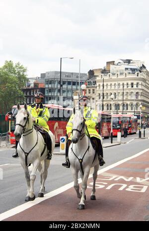 Zwei britische Polizisten patrouillieren zu Pferd auf den Straßen einiger Londoner Straßen in der Hauptstadt des Vereinigten Königreichs Stockfoto