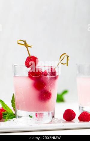 Himbeer-Vodka-Shots Limonade Cocktail mit frischem Himbeer auf weißem Holzhintergrund. Stockfoto