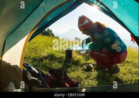 Frankreich, Isère (38), Parc naturel régional du Vercors, Saint-Nizier-du-Moucherotte, le Plateau de Sornin, randonneuse préparant le thé du Merin après une nuit en biwaac Stockfoto