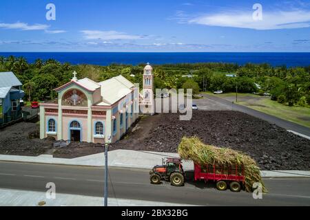 Frankreich, Réunion Island (Französisch Übersee-Department), die Notre-Dame-des-Laves Kirche von Piton Sainte-Rose verschont durch den Lavastrom von 1977, Traktor mit einer Ladung Zuckerrohr zur Zuckerfabrik (Luftaufnahme) Stockfoto