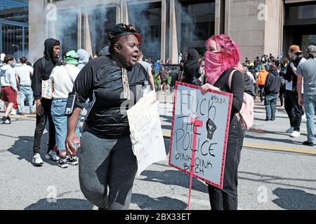 Ein schwarzes Frauengesicht wird mit Milch überzogen, um die Wirkung von Pfefferspray zu neutralisieren, das während der Proteste in Cleveland, Ohio, USA, geschossen wurde. Stockfoto