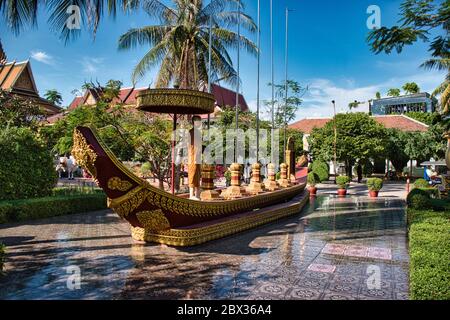 Ein riesiges goldenes Bootsdenkmal im Wat Preah Prom Rath ein wunderschöner historischer buddhistischer Tempelkomplex mit bunten Pagoden auf einem großen Grundstück Stockfoto