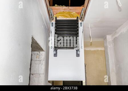 Schiebetür Metalltreppe zum Dachboden in der Decke, eine offene Luke und Verbindungs-Treppe, modernes Aussehen. Stockfoto