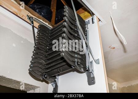 Schiebetür Metalltreppe zum Dachboden in der Decke, eine offene Luke und Verbindungs-Treppe, modernes Aussehen. Stockfoto