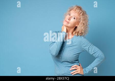 Lächelnde ältere Frau vor blauem Hintergrund Stockfoto
