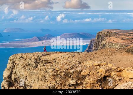 Spanien, Kanarische Inseln, Lanzarote, Naturpark Chinijo Archipel, Wanderung auf den Klippen von Famara (Risco de Famara), La Graciosa im Hintergrund Stockfoto