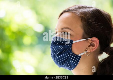 Frau In Wiederverwendbaren Stoff Gesichtsmaske. Covid-19 Quarantine Mode Stockfoto