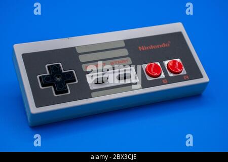 Nintendo NES-Controller. Nahaufnahme eines klassischen Vintage Gamepad mit einem bunten blauen Hintergrund. Malaga, Spanien - 04. Juni 2020 Stockfoto