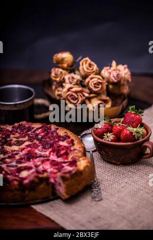 Traditionelle hausgemachte Erdbeerkuchen Dessert mit frischen Erdbeeren auf Vintage-Holz Hintergrund. Dunkle Lebensmittel Foto, rustikalen Stil, natürliches Licht. Stockfoto