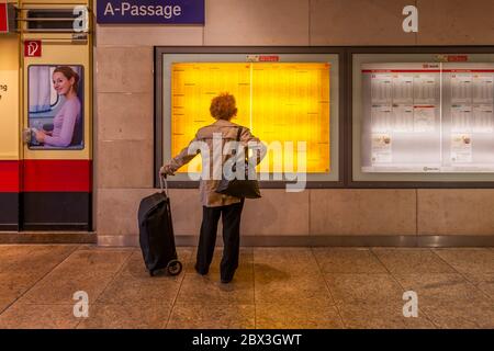 Ein Reisender studiert den Fahrplan am Kölner Hauptbahnhof Stockfoto