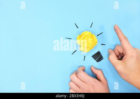 Gelbe Glühbirne in blauem Hintergrund flach gelegt. Strahlende neue Ideen und denkende Lösungskonzepte. Stockfoto