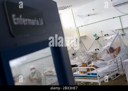 Manaus, Brasilien. Juni 2020. Ein Patient wird mit dem nicht-invasiven Beatmungssystem „Capsule Vanessa“ im städtischen Feldkrankenhaus Gilberto Novaes behandelt. Das Feldlazarett wurde in einer Schule eingerichtet und verfügt über 180 Betten, darunter 38 Intensivbetten. Kredit: Lucas Silva/dpa/Alamy Live News Stockfoto