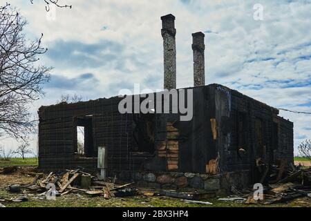 20. April 2020, Jekabpils, Lettland: Verkohlte Holzteile eines verbrannten Hauses Stockfoto