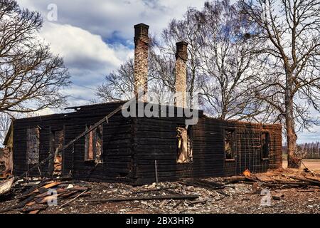 20. April 2020, Jekabpils, Lettland: Verkohlte Holzteile eines verbrannten Hauses Stockfoto