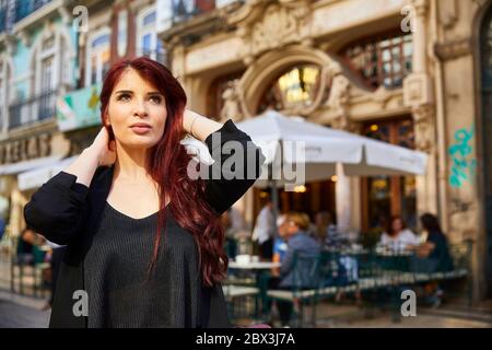 Eine Portugiesin steht vor dem Café Majestic an der Rua de Santa Catarina in Porto, Portugal. Stockfoto