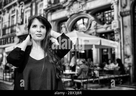 Eine Portugiesin steht vor dem Café Majestic an der Rua de Santa Catarina in Porto, Portugal. Stockfoto