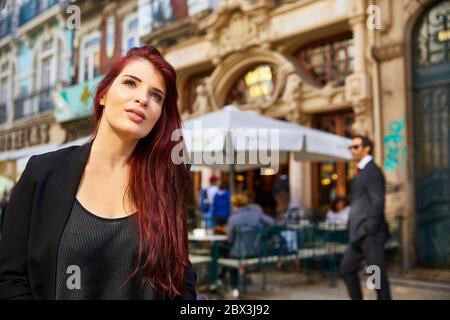 Eine Portugiesin steht vor dem Café Majestic an der Rua de Santa Catarina in Porto, Portugal. Stockfoto