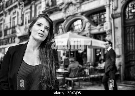 Eine Portugiesin steht vor dem Café Majestic an der Rua de Santa Catarina in Porto, Portugal. Stockfoto