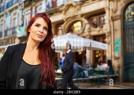 Eine Portugiesin steht vor dem Café Majestic an der Rua de Santa Catarina in Porto, Portugal. Stockfoto