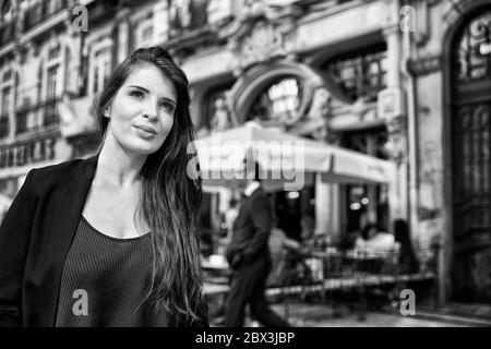 Eine Portugiesin steht vor dem Café Majestic an der Rua de Santa Catarina in Porto, Portugal. Stockfoto