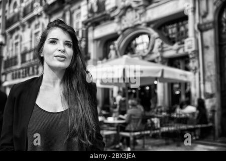 Eine Portugiesin steht vor dem Café Majestic an der Rua de Santa Catarina in Porto, Portugal. Stockfoto