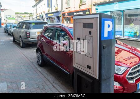Autos auf der Straße neben einem Münzzähler in Bandon, West Cork, Irland. Stockfoto