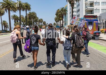 Santa Monica, USA. Juni 2020. Eine Gruppe von Demonstranten marschiert in Erinnerung an George Floyd. Floyd, der von Minneapolis Police getötet wurde, wurde heute begraben. Sgt. Leyva von der Polizei von Santa Monica marschiert Hand in Hand mit Demonstranten. 4/2020 Santa Monica, CA USA (Foto: Ted Soqui/SIPA USA) Quelle: SIPA USA/Alamy Live News Stockfoto