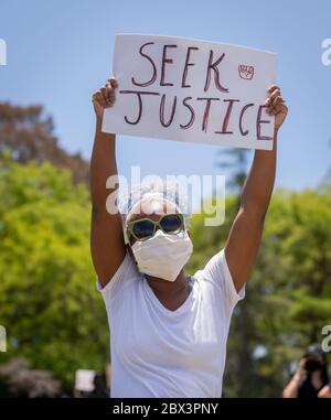 Protestierende mit Schild an der Demonstration zu Ehren von George Floyd, im Pan Pacific Park im Fairfax Viertel von Los Angeles, Kalifornien. Stockfoto