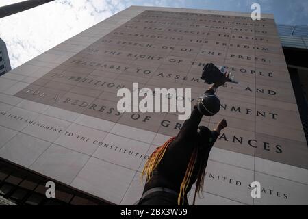 Washington, Usa. Juni 2020. Eine Protestierende hebt ihre Arme, während sie am alten Newseum vorbei geht, wo der erste Verfassungszusatz bei Demonstrationen gegen Polizeibrutalität und den Tod von George Floyd am Donnerstag, den 4. Juni 2020 in Washington, DC, gezeigt wird. Demonstrationen im ganzen Land über den Tod von George Floyd, der in Polizeigewahrsam in Minneapolis am 25. Mai getötet wurde fortgesetzt. Foto von Ken Cedeno/UPI Quelle: UPI/Alamy Live News Stockfoto