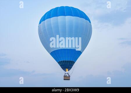 Blauer Heißluftballon über dem Land. Stockfoto