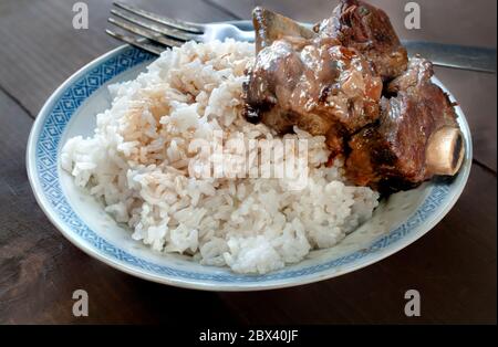 Nahaufnahme, Makrofotografie von Rippen in Austernsauce auf einem Teller Reis, asiatische Lebensmittel-Konzept Stockfoto
