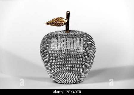 Mit Strass besetzte Apfeldeko mit Goldstamm und Blattgold. High-Key-Studioaufnahme. Stockfoto