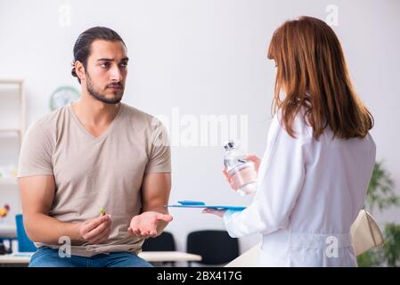 Männlicher Diabetiker, der einen jungen Arzt besucht Stockfoto