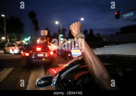 Los Angeles, Usa. Juni 2020. Ein Protestler hebt während der Demonstration seine Faust aus dem Fahrersitz seines Autos in die Luft. Demonstranten gingen auf die Straßen Hollywoods, um gegen den Tod George Floyd zu marschieren. Obwohl die Proteste friedlich waren, wurden viele Demonstranten verhaftet, weil sie der Ausgangssperre von Los Angeles nicht gehorchten, die wegen früherer gewalttätiger Proteste und Plünderungen eingerichtet wurde. Quelle: SOPA Images Limited/Alamy Live News Stockfoto