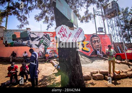 Nairobi, Kenia. Juni 2020. Bewohner entspannen vor einer bemalten Wand mit einer Kunst von George floyd, einem schwarzen Mann, der von einem Polizisten in Minneapolis getötet wurde. Quelle: SOPA Images Limited/Alamy Live News Stockfoto