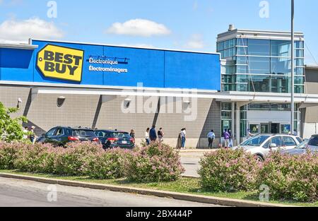 Montreal, Kanada - 30. Mai 2020: Eine Reihe von Menschen, die Masken tragen, warten draußen, um Best Buy zu betreten. Best Buy ist ein multinationaler amerikanischer Verbraucher Stockfoto