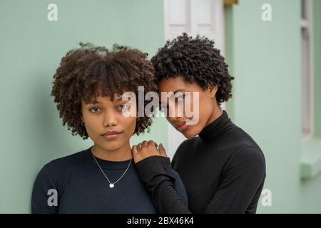 Porträt von zwei stilvollen Schwestern mit lockigen Haaren. Stockfoto
