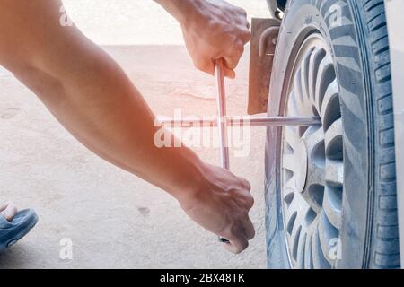 Die mechanischen Reifenreparaturen entfernen die Räder. Mit Werkzeugen Stockfoto