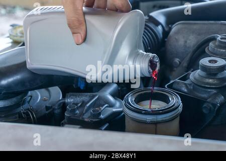 Nahaufnahme Hände des Mechanikers tun Auto-Service und Wartung. Hydrauliköl wechseln neu ersetzen Stockfoto