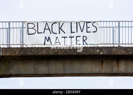 Banner mit schwarzer Lebensgefahr, das an Geländern der Fußgängerbrücke über die zweispurige A41 in Tring, Hertfordshire, befestigt ist. Das Banner stand dem Verkehr gegenüber, der nach Norden reiste. Black Lives Matter haben prominent in Protest gegen die Tötung von George Floyd. Kredit: Stephen Bell/Alamy Stockfoto