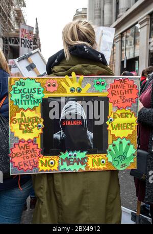 London, Großbritannien, 7. März 2020. Die 13. Million Women Rise marschieren jährlich durch Central London. Marsch gegen männliche Gewalt an Frauen und Mädchen. Eine Frau am versammlungspunkt im märz in der Duke Street mit einem Plakat auf dem Rücken. Die lebendige Plakat sagte Keine Entschuldigung für Schlagen, Wir verdienen frei zu sein, Nein bedeutet Nein, Wir haben das Recht, sicher zu sein, Stalker, Stop. Kredit: Stephen Bell/Alamy Stockfoto