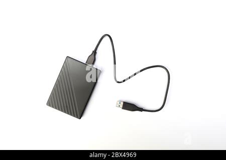 Festplatte oder HDD auf weißem Hintergrund. Externe Festplatte zum Speichern von Speicher mit Draht. Flat Lay Stockfoto