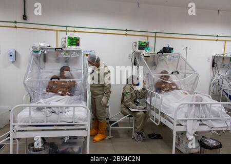 Manaus, Brasilien. Juni 2020. Krankenschwestern im Gespräch mit Patienten in der Intensivstation des städtischen Feldkrankenhauses Gilberto Novaes. Das Feldlazarett wurde in einer Schule gegründet und verfügt über 180 Betten, davon 38 Intensivbetten. Kredit: Lucas Silva/dpa/Alamy Live News Stockfoto