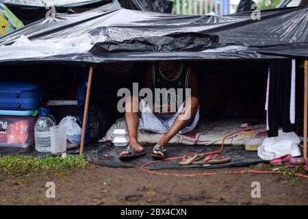 Gestrandete Venezolaner bauen ein provisorisch behelfsmäßiges Lager in einem baumbestandenen Park inmitten der Covid-19-Pandemie und warten auf die Möglichkeit, in ihr Land, Cali, Stockfoto