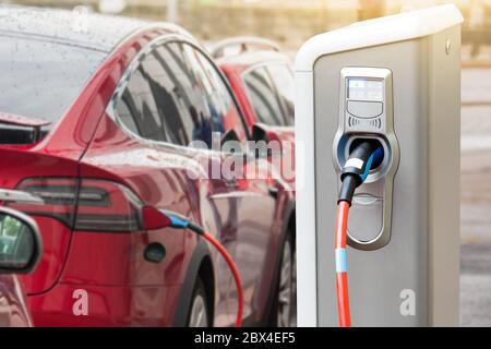 Ladestation auf dem Hintergrund eines Elektroautos. Stockfoto