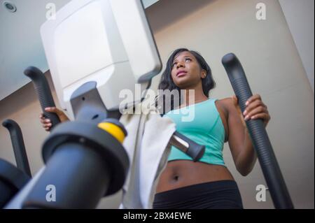 Drinnen Fitness-Studio Porträt von jungen attraktiven und konzentrierten schwarzen african American Frau Training elliptische Maschine Training im Fitness-Club arbeiten har Stockfoto