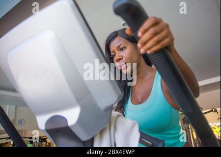 Drinnen Fitness-Studio Porträt von jungen attraktiven und konzentrierten schwarzen african American Frau Training elliptische Maschine Training im Fitness-Club arbeiten har Stockfoto